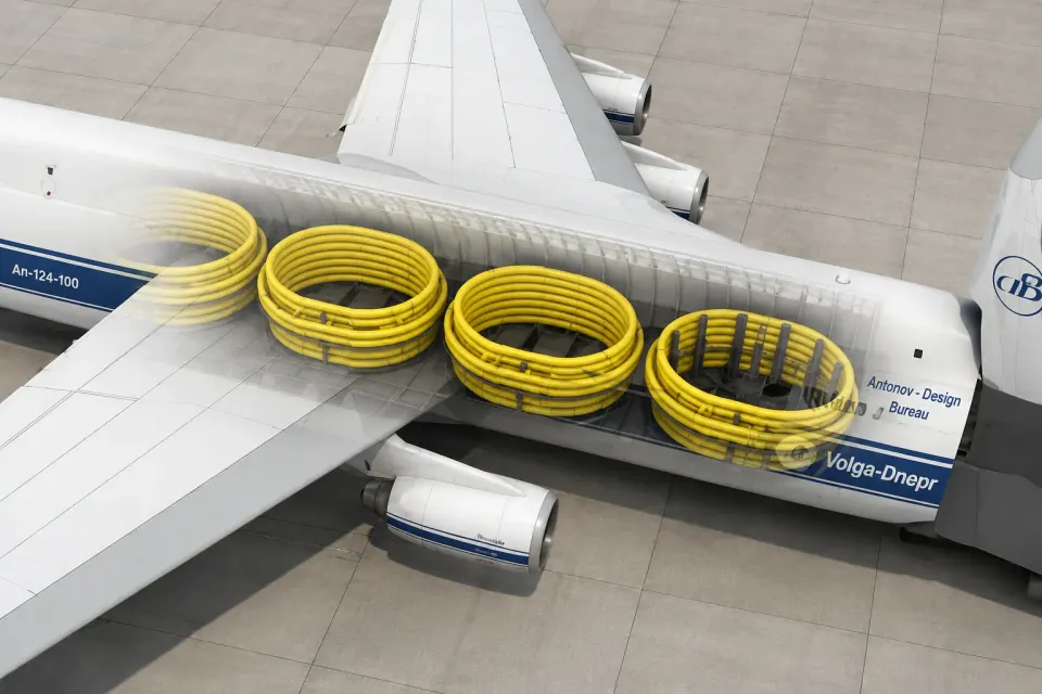 Overhead cutaway view of four coiled pipe carousels stowed in a cargo aircraft's hold