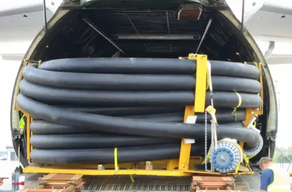 Coiled flexible pipe strapped to a frame inside a cargo aircraft hold