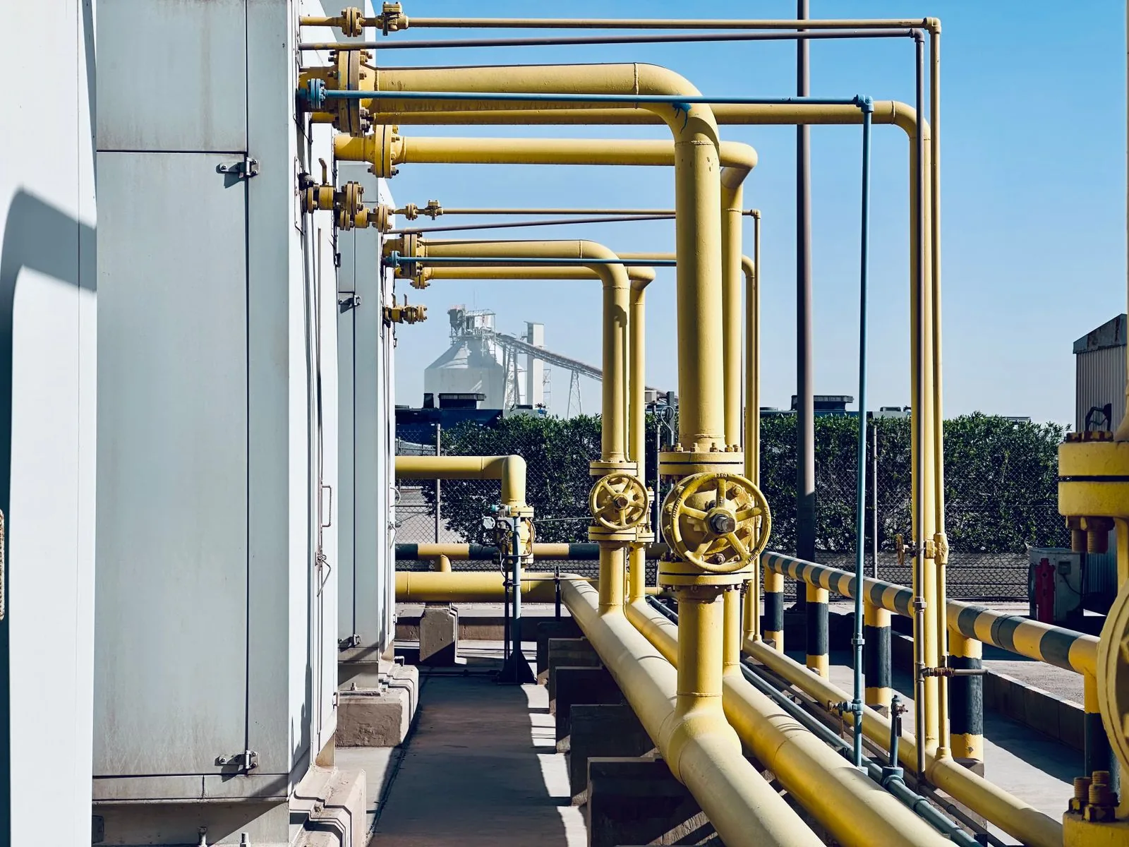 Rows of golden industrial pipelines at an energy processing facility